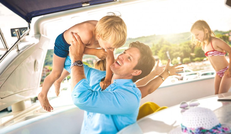 a dad playing with his kids on a boat