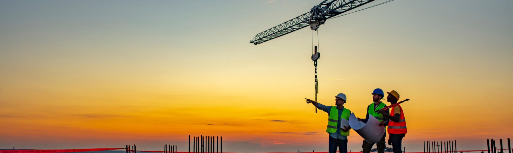 construction workers on a rooftop at sunset