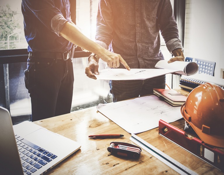 Two Architect man working with compasses and blueprints for architectural plan,engineer sketching a construction project concept.