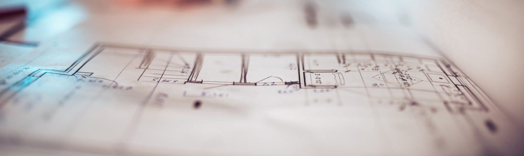 a man writing on blueprints