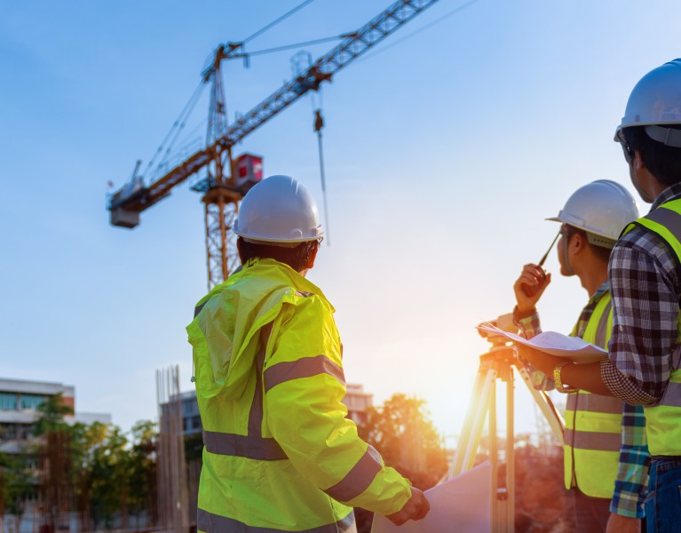 construction engineers looking at building site with a crane
